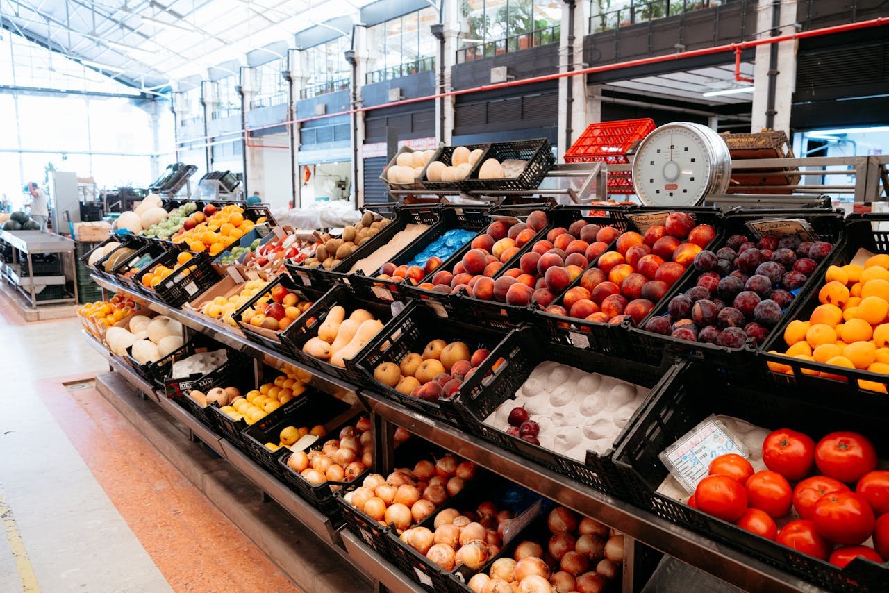 Colorful variety of fruits in a market stand showcasing freshness and abundance indoors.